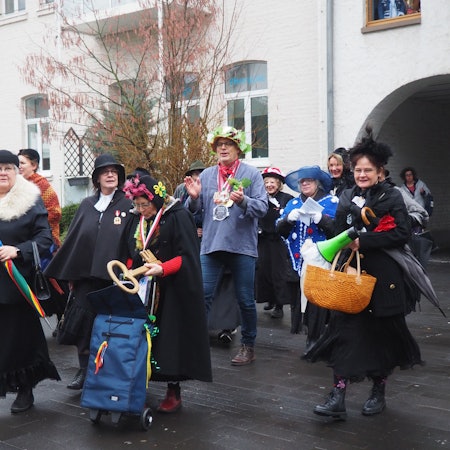 Die Möhnen haben Bürgermeister Hürtgen in ihre Mitte genommen auf dem Weg zum Feiern.