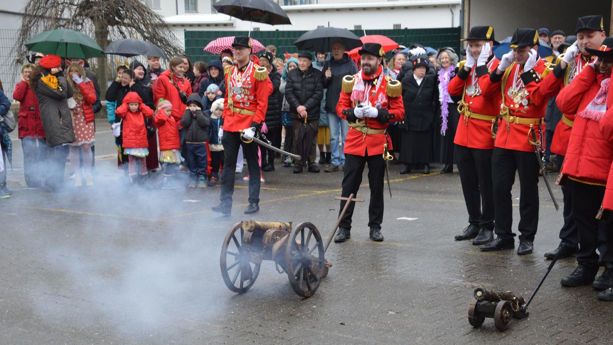 Die Kanone der Prinzengarde qualmt. Zuschauer und Prinzengardisten halten sich die Ohren zu.