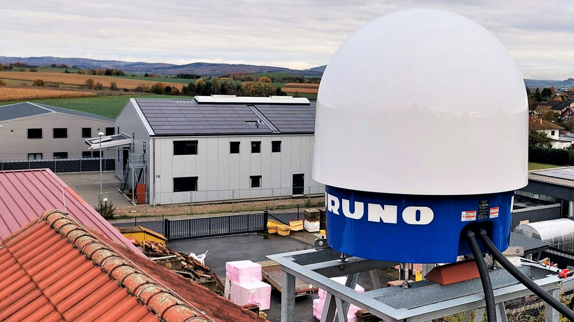 Zu sehen ist ein X-Band-Niederschlagsradar der Mittelhessischen Wasserbetriebe, das auf einem Dach montiert ist.