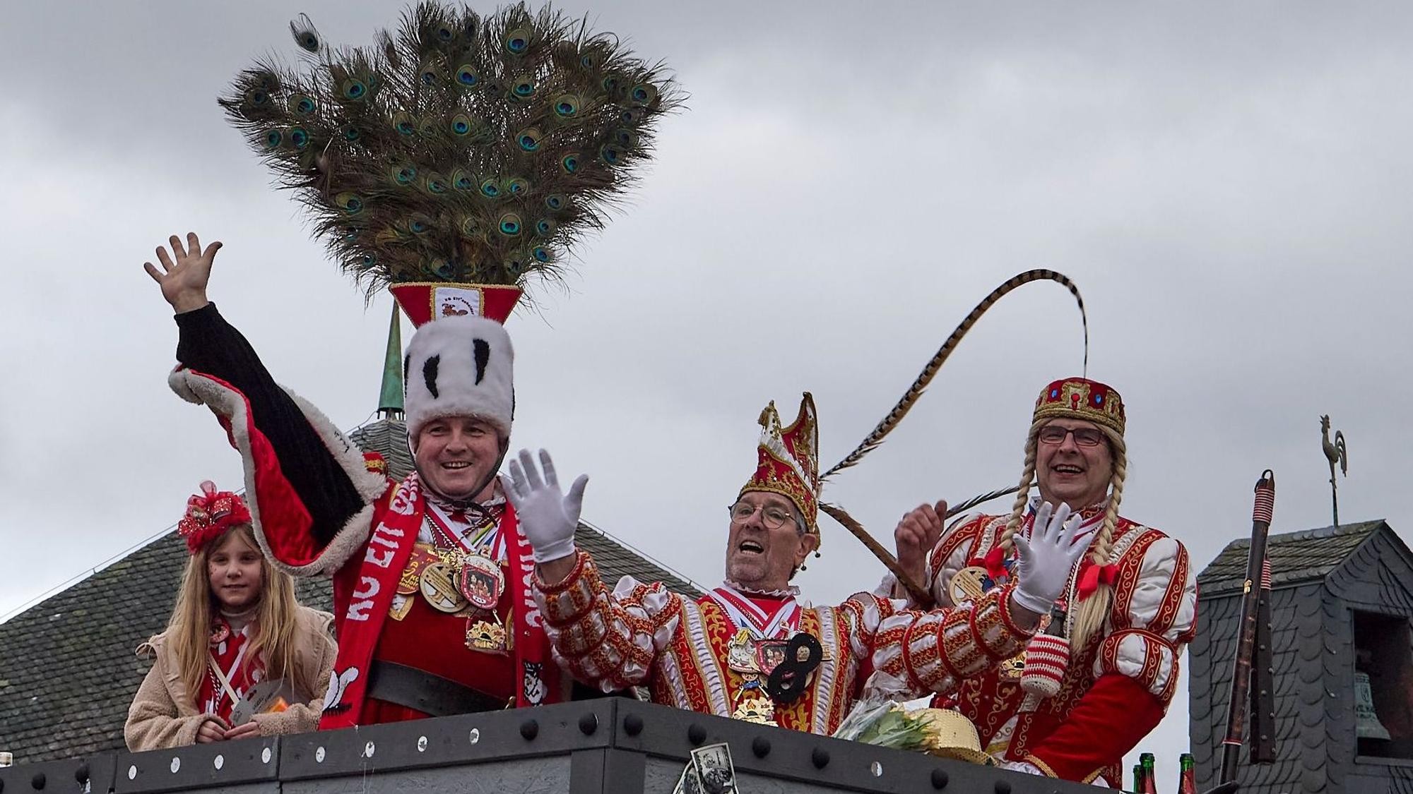 Das Ettelscheider Dreigestirn grüßt fröhlich vom Wagen.