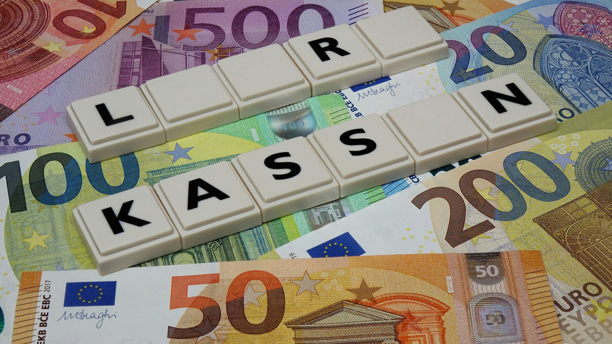 Auf verschiedenen Geldscheinen wurde mit Buchstabensteinen der Schriftzug leere Kassen gelegt.