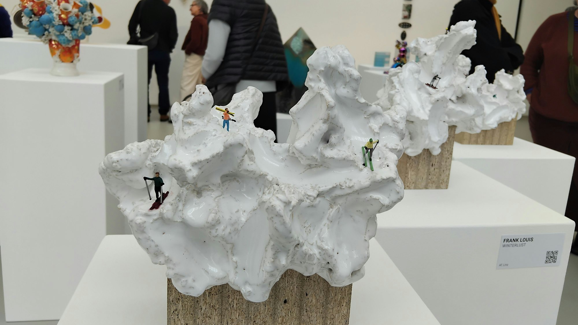 Keramik wurde wie Schnee geformt. Skifahrer aus Keramik sind im „Schnee“ unterwegs.