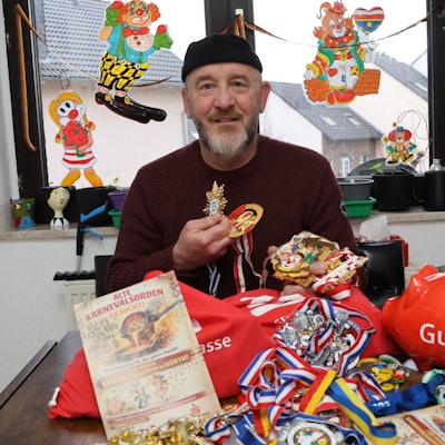 Das Foto zeigt Karl Zisterer mit Jutebeuteln voller Orden vor sich auf dem Tisch.