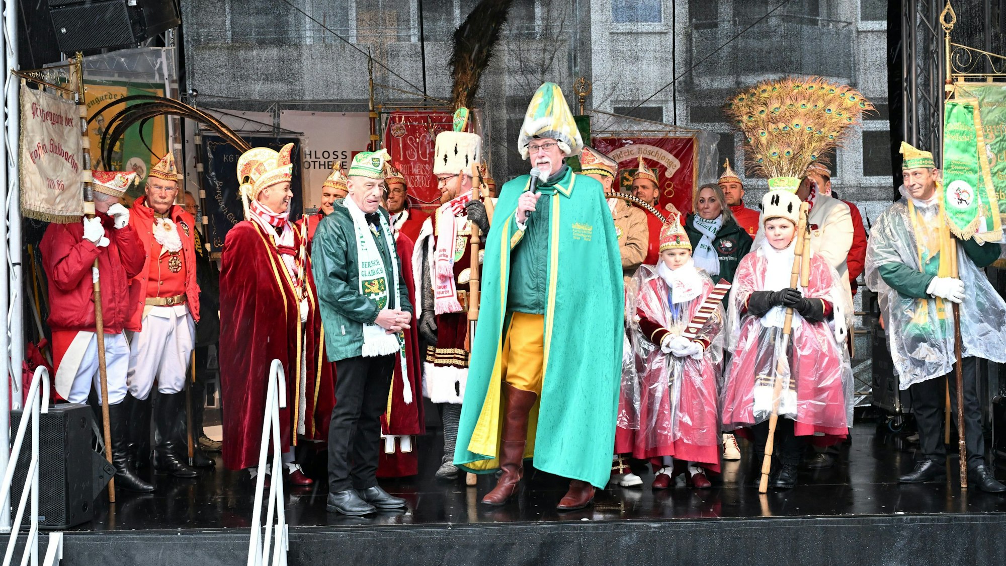 Viele Kostümierte auf einer Bühne. In der Mitte ein Kommandant mit Federhelm.
