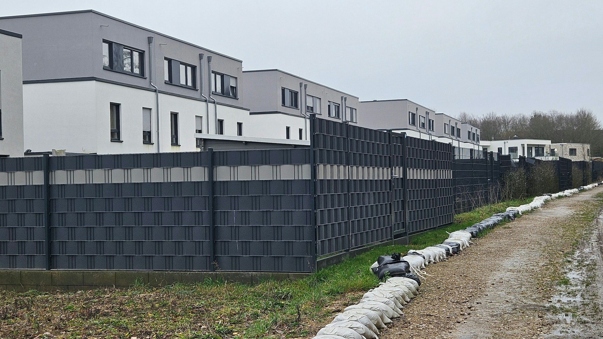 Zu sehen ist eine Reihenhaussiedlung, vor deren Gärten Sandsäcke liegen.