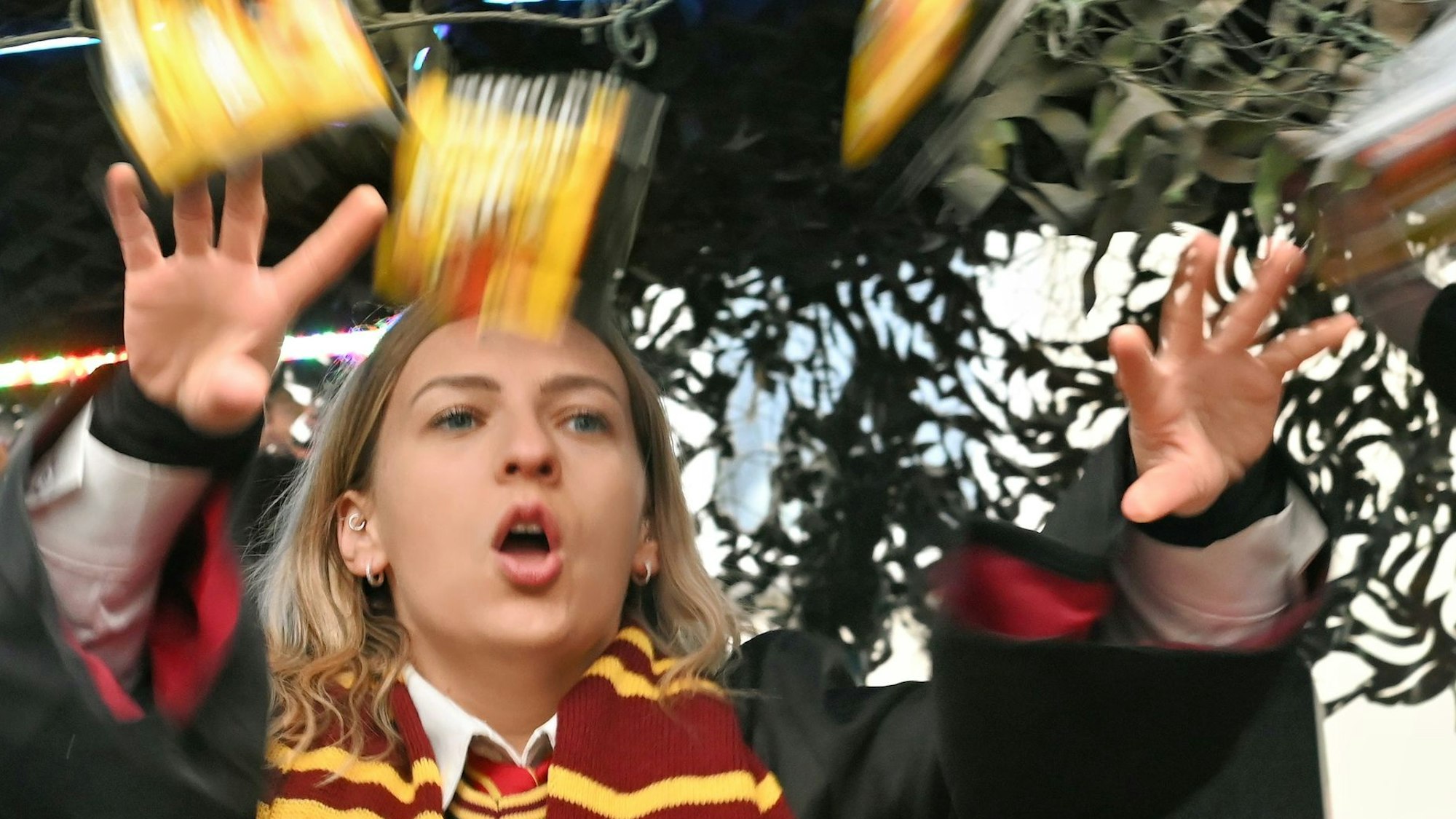 Eine Karnevalistin wirft im Zug in Euskirchen-Billig Süßigkeiten von einem Wagen.