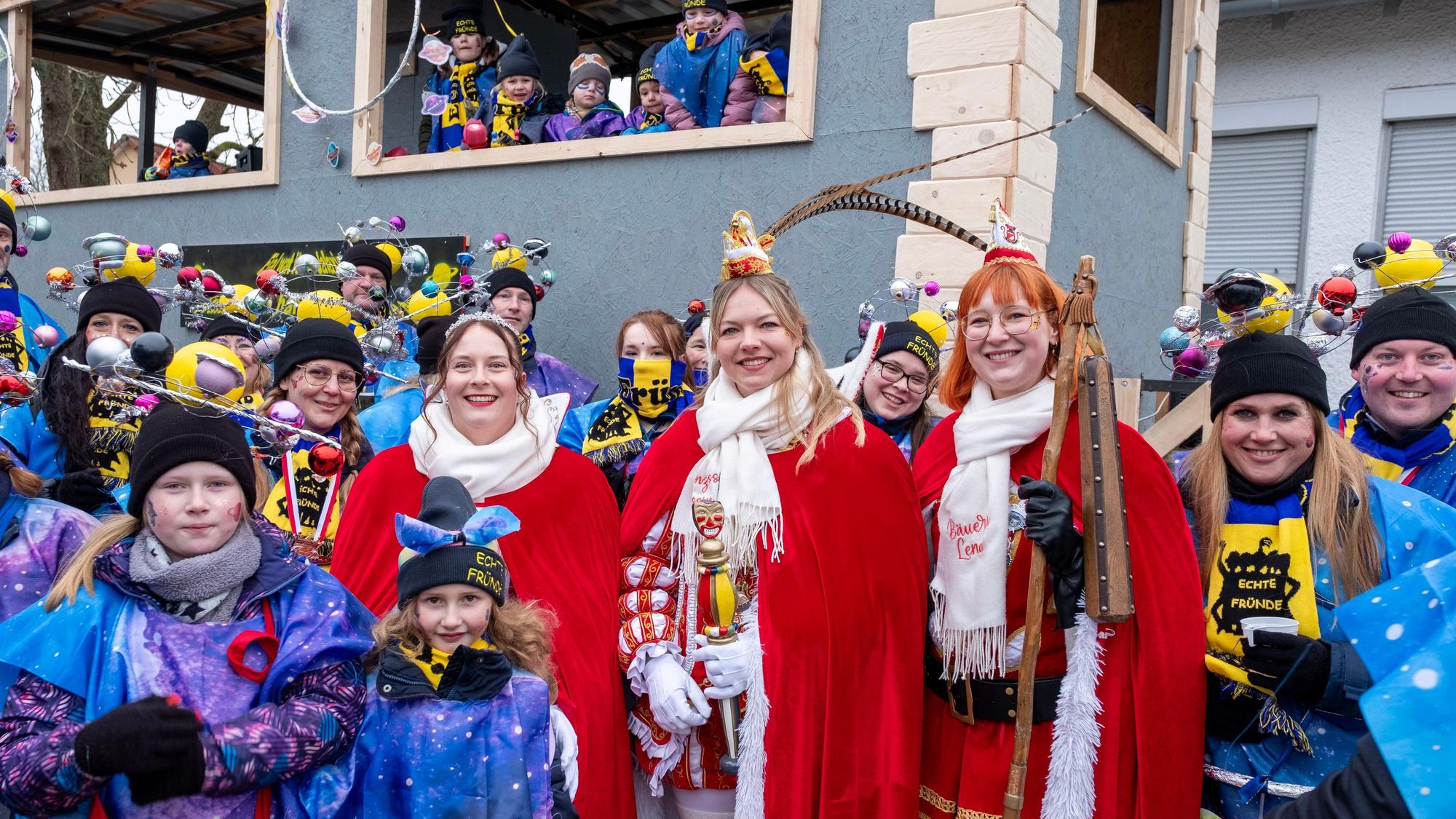 Das Foto zeigt das Dreigestirn und viele kostümierte Jecken