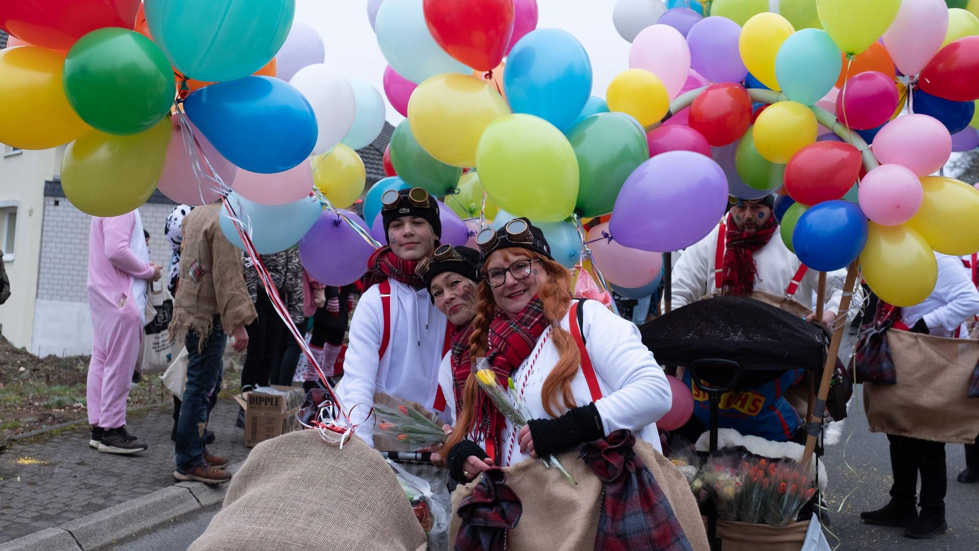 Das Foto zeigt Jecke mit bunten Ballons