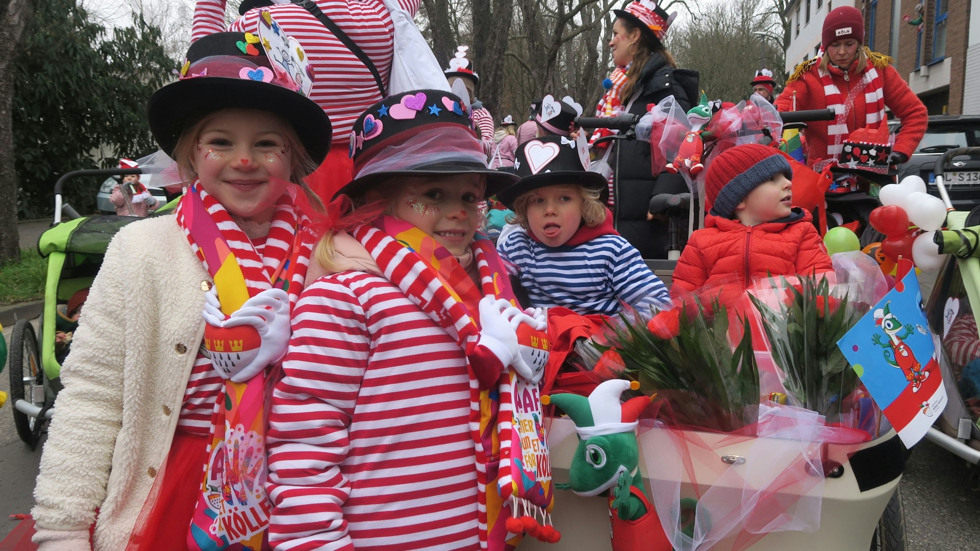 Kinder in Ringelshirts stehen um einen Behälter mit Strüßjer.