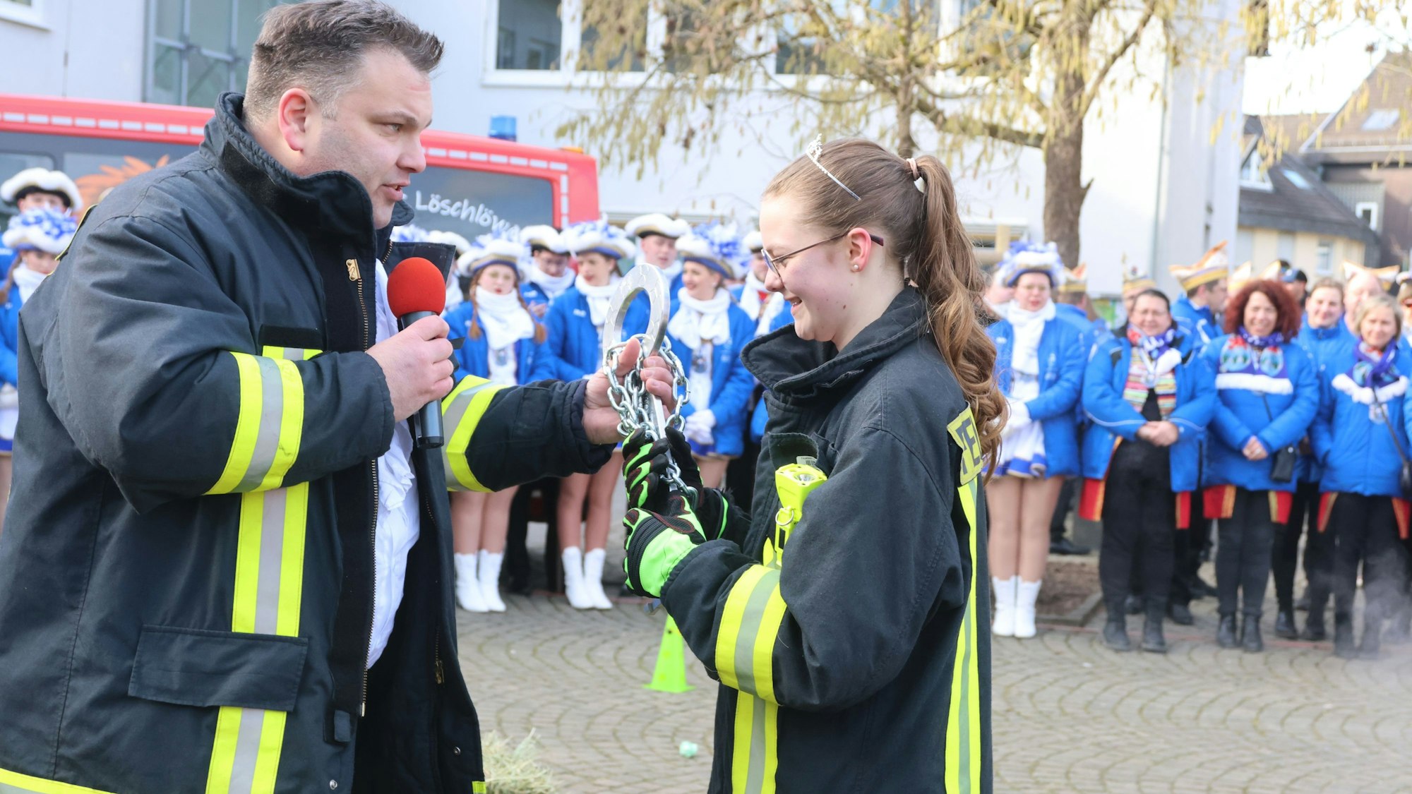 Der Bürgermeister übergibt Liya den Schlüssel.