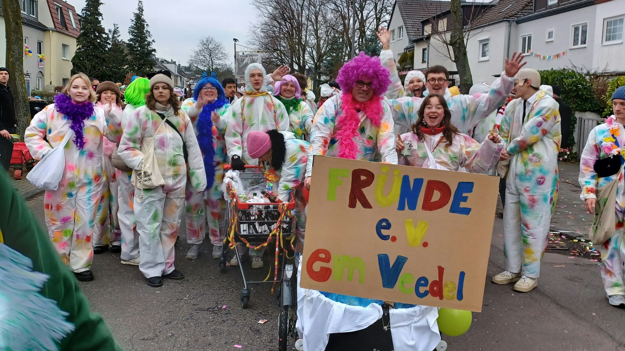 Eine Fußgruppe ist in bunten Maleranzügen unterwegs.