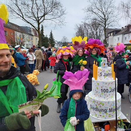 Eine Fußgruppe hat eine Geburtstagstorte dabei.