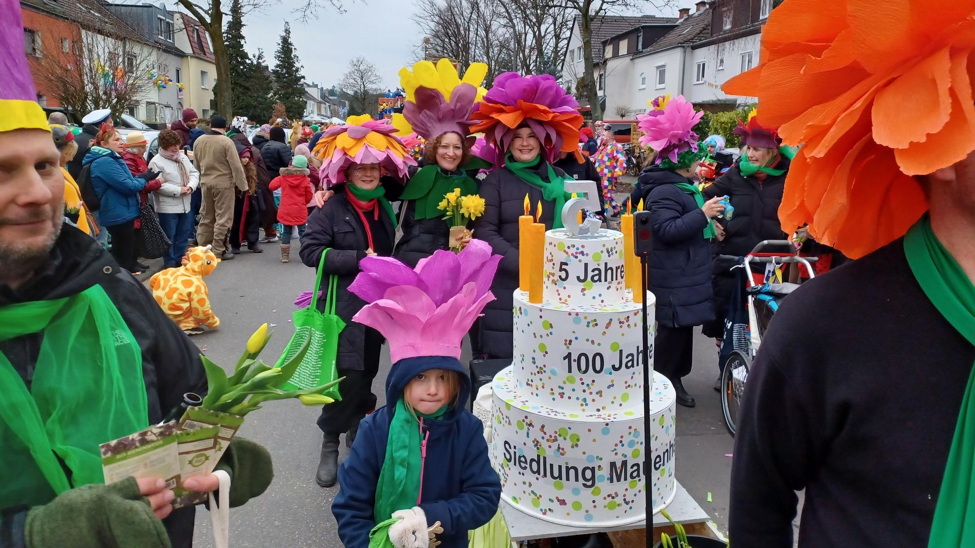 Eine Fußgruppe hat eine Geburtstagstorte dabei.