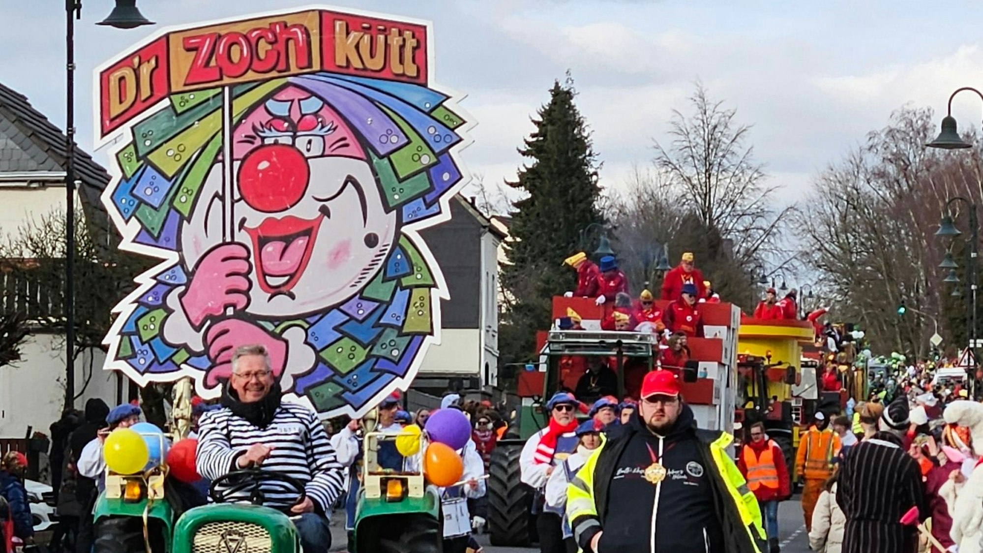 Auf einem Traktor ist ein Schild befestigt, das einen Clown zeigt.