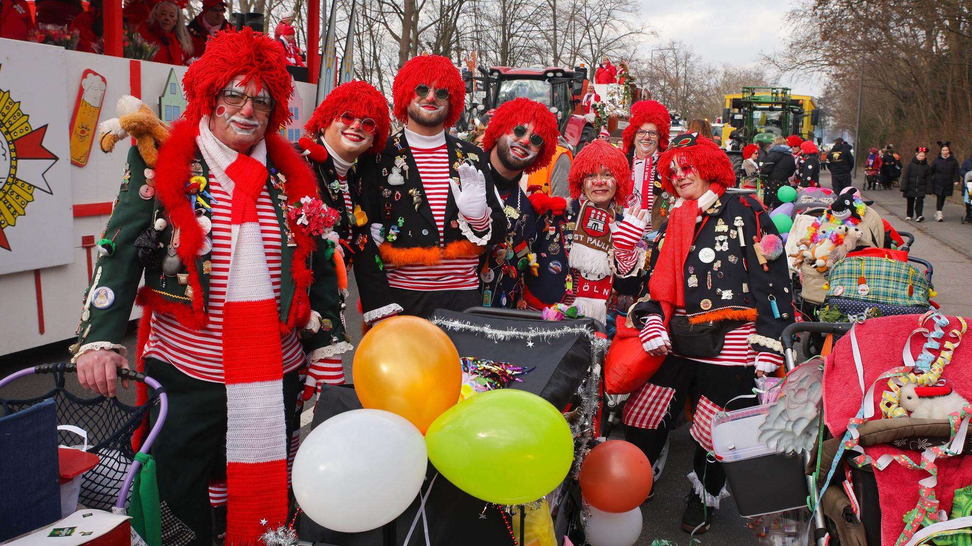 Eine Fußgruppe in Rot-Weiß und mit Luftballons ist unterwegs.