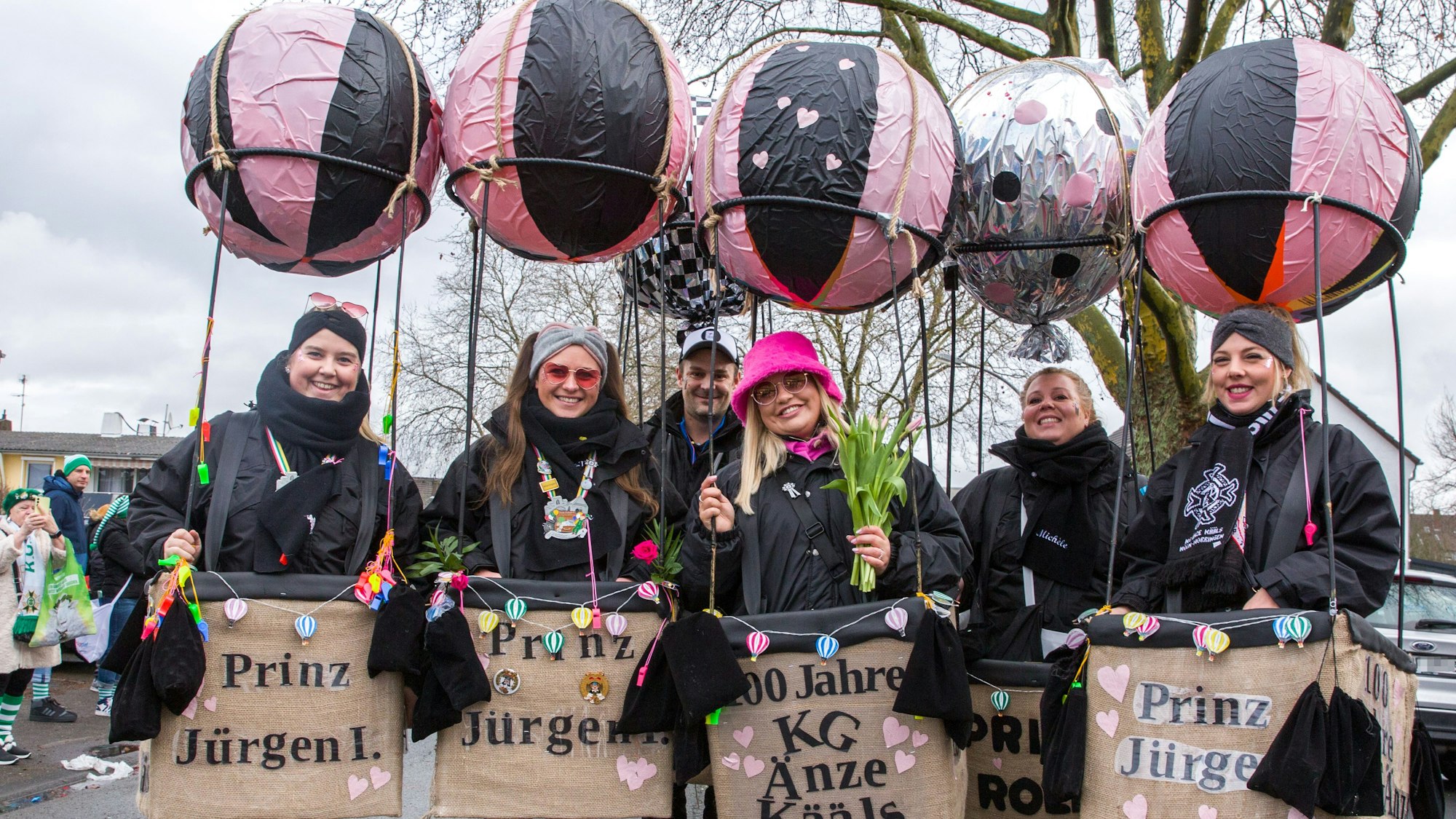 Fünf Frauen mit schwarz-pinken Ballonkostümen lachen in die Kamera.