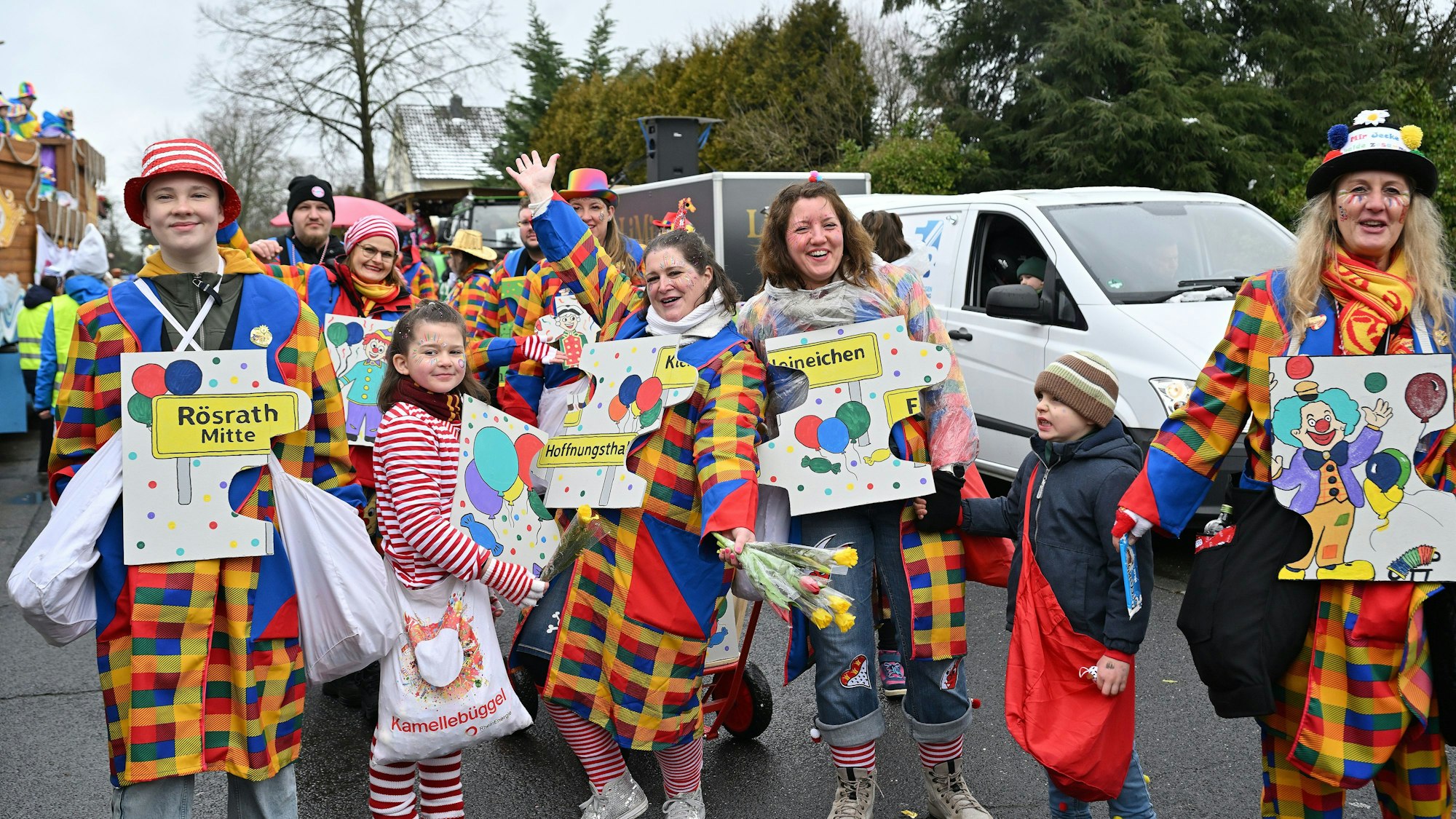 Eine Gruppe bunt gekleideter Leute mit großen Puzzleteilen aus Pappe vor der Brust, auf denen die Namen der Rösrather Stadtteile stehen.