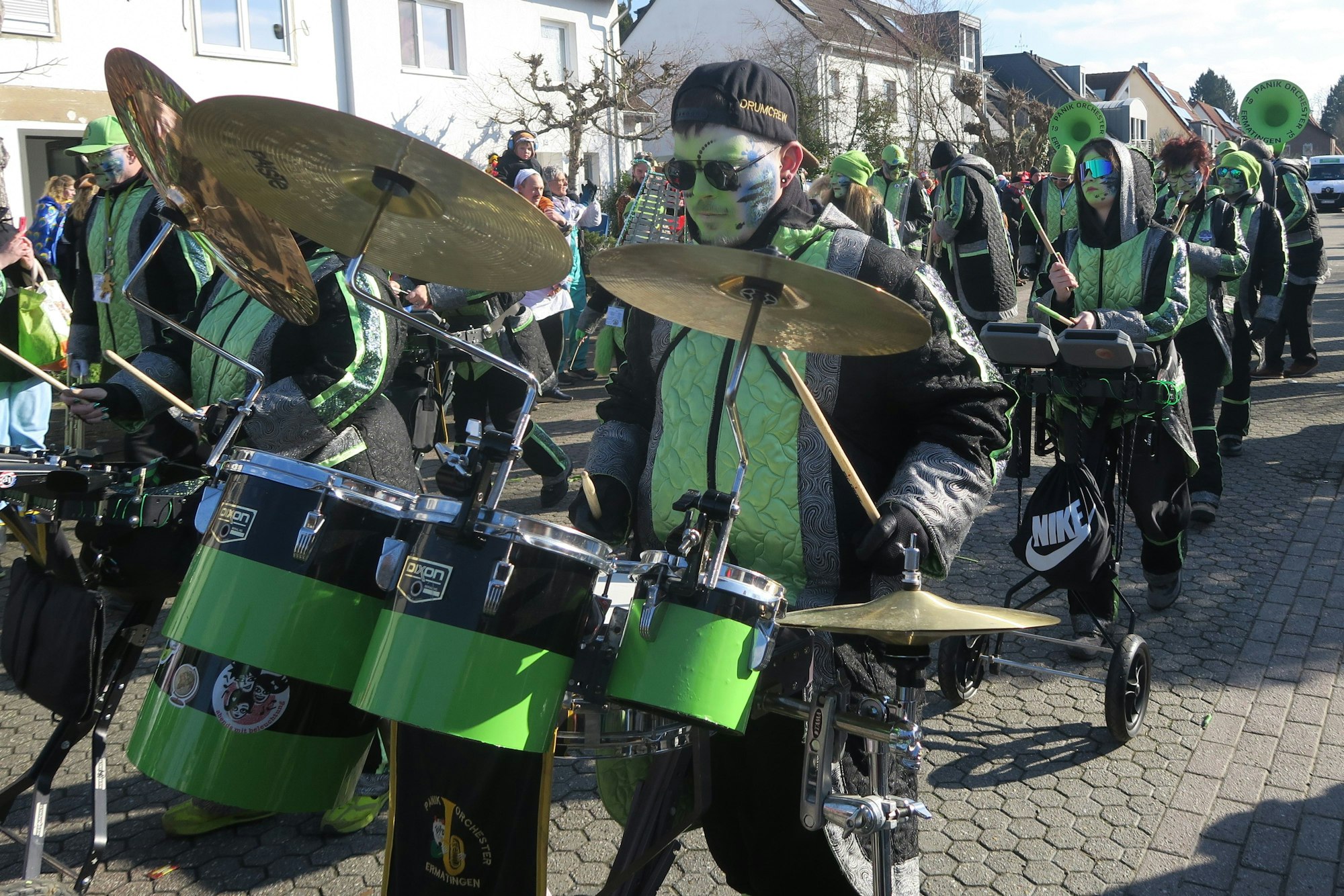 Eine Gruppe grün-schwarz gekleideter Musiker ist im Zug unterwegs.