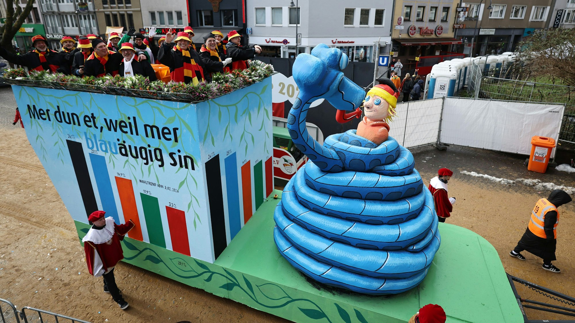 Ein Motivwagen mit einer blauen Schlange Kaa, die den deutschen Michel hypnotisiert, nimmt am Rosenmontagszug in Köln teil.
