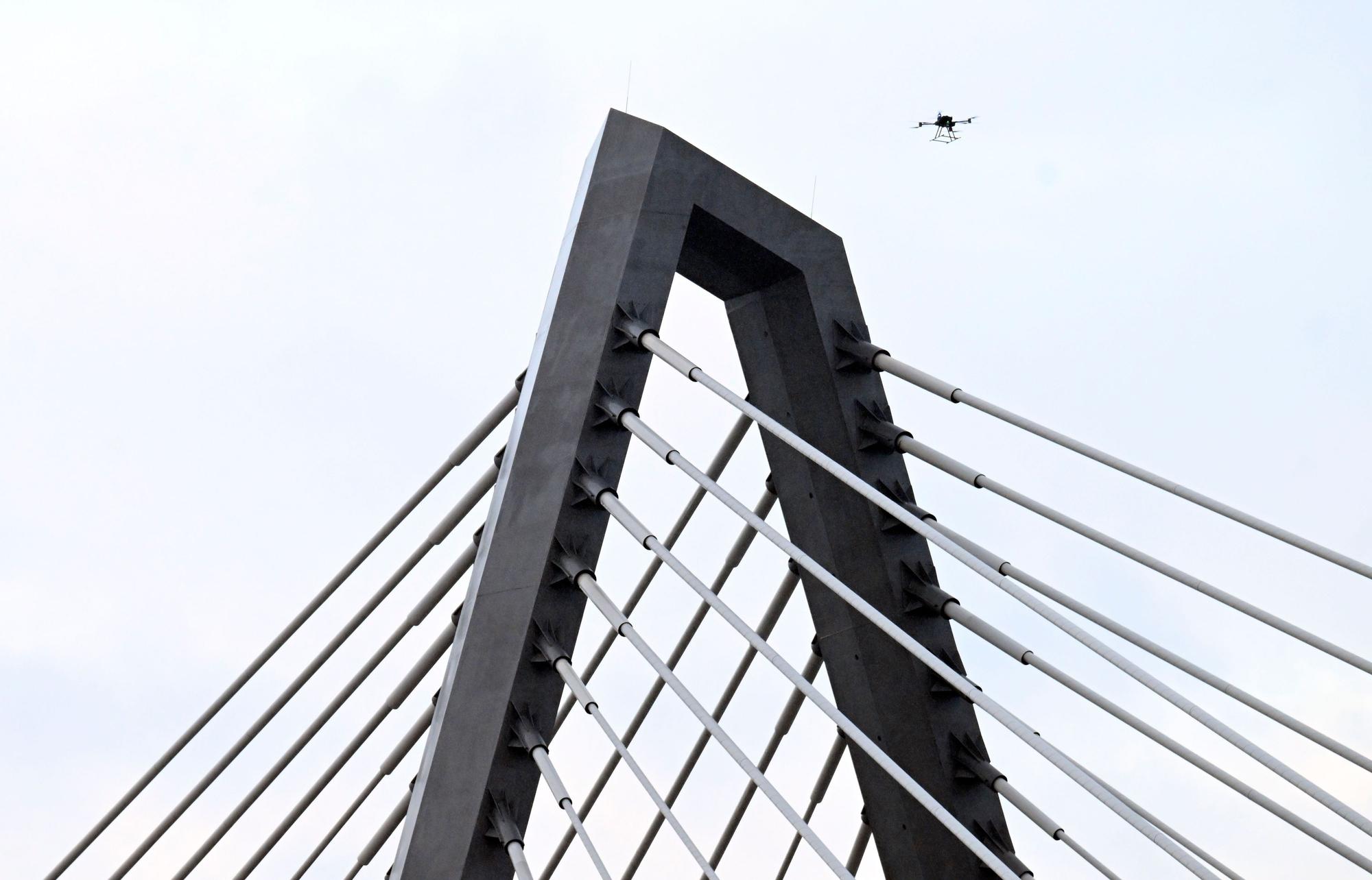 16.02.2026, Nordrhein-Westfalen, Leverkusen: Eine Drohne steigt neben den Drahtseilen der Leverkusener Rheinbrücke auf, um den Zustand der Konstruktion zu überprüfen. Die Autobahnmeisterei sperrte die Autobahn 1 (A1) in beide Richtungen, nachdem sich über Nacht Eis gebildet hatte, das auf darunter fahrende Fahrzeuge hätte stürzen können. Foto: Roberto Pfeil/dpa +++ dpa-Bildfunk +++