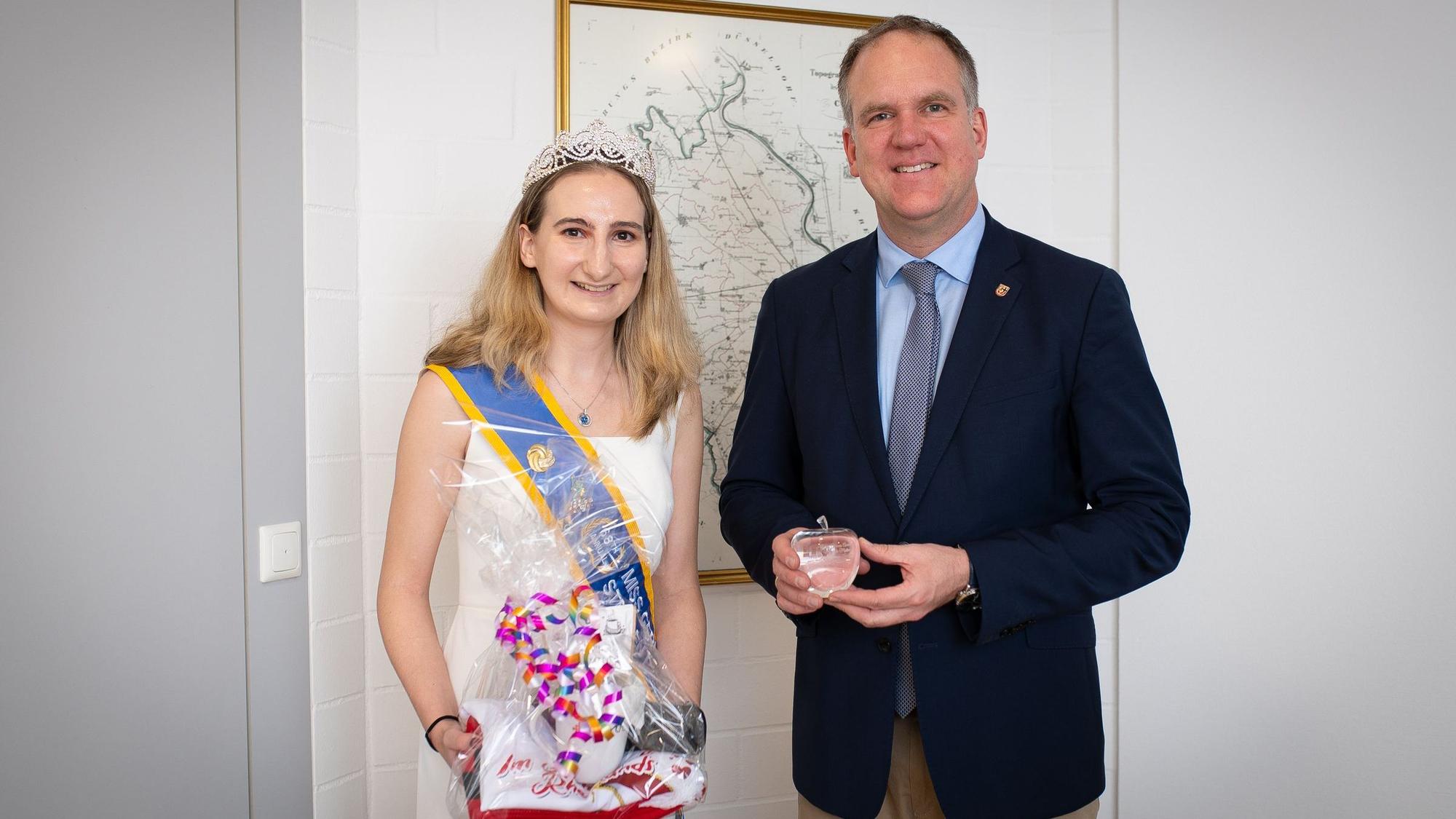 Das Foto zeigt die Kornblumenkönigin und den Bürgermeister im Rathaus vor einer historischen Karte von Hürth.