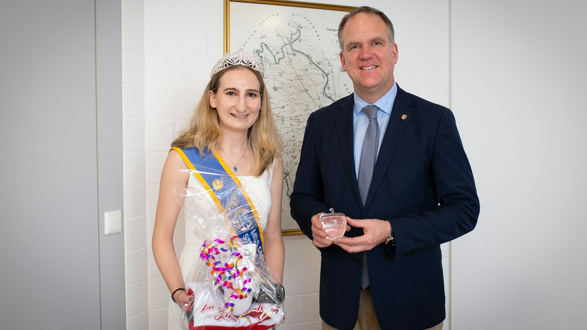 Das Foto zeigt die Kornblumenkönigin und den Bürgermeister im Rathaus vor einer historischen Karte von Hürth.
