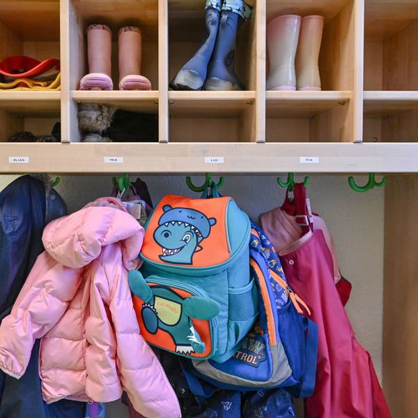 Kleidung von Kindern hängt in einer Kita.
