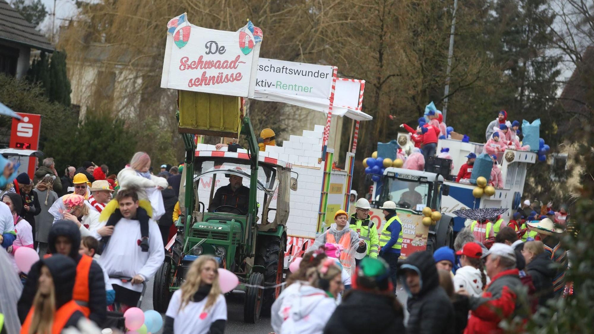 Zwei Mottowagen im Karnevalszug in Aegidienberg, viele Zuschauer am Straßenrand.