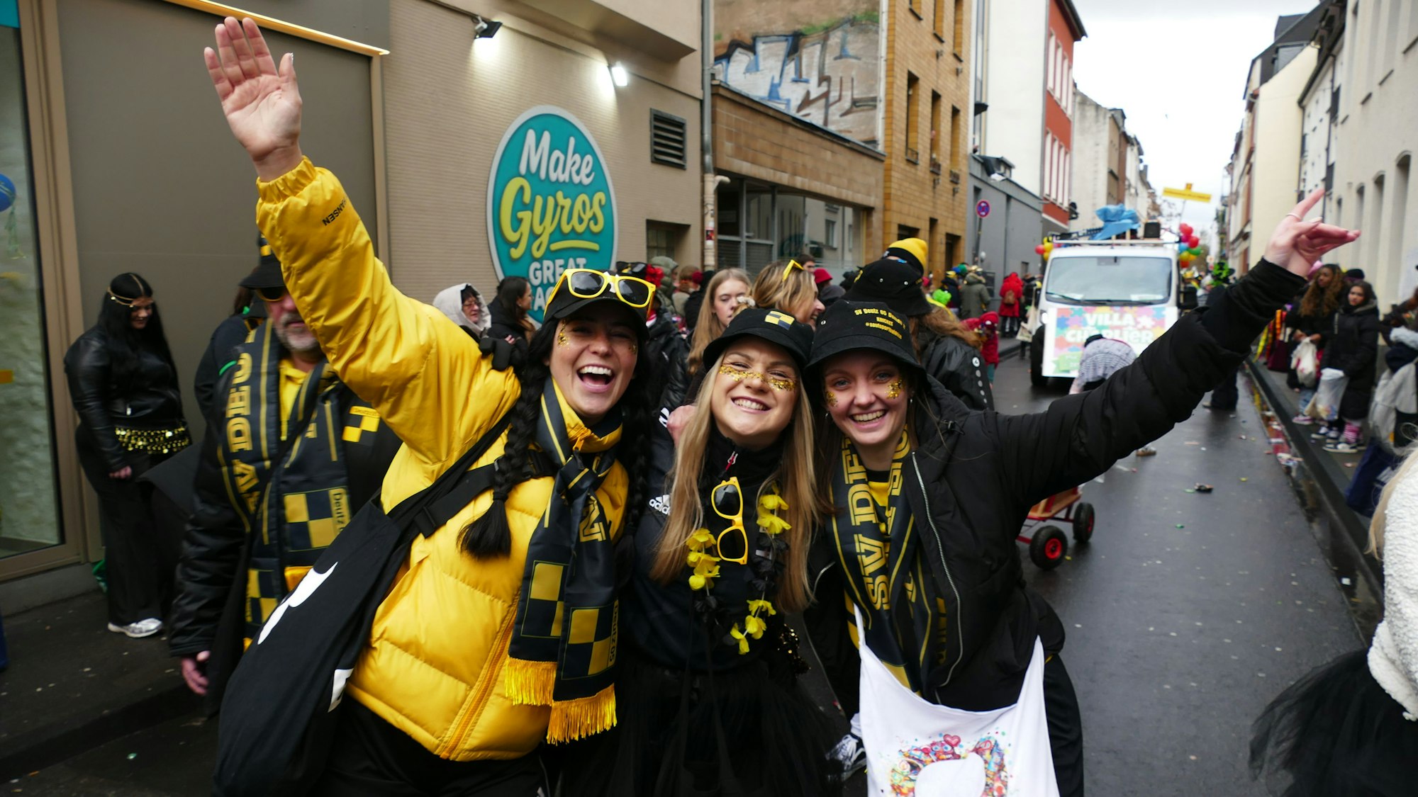 Drei Frauen in Schwarz-Gold stehen zusammen auf dem Zugweg.
