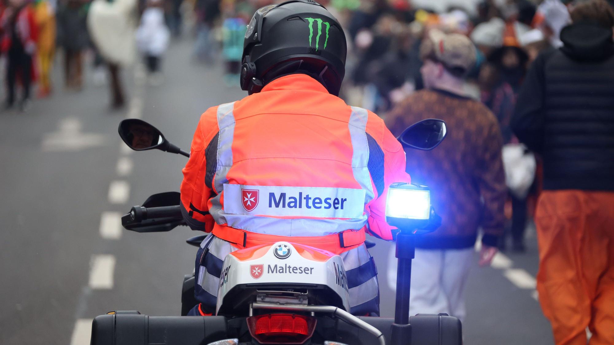 Eine Einsatzkraft des Malteser Hilfsdiensts ist auf einem Motorrad im Südstadtzug in Euskirchen im Einsatz.