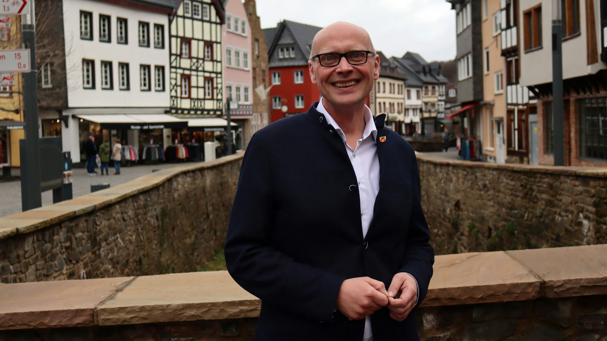 Sebastian Glatzel steht auf einer Brücke, die über die Erft führt. Im Hintergrund sieht man Bad Münstereifel.