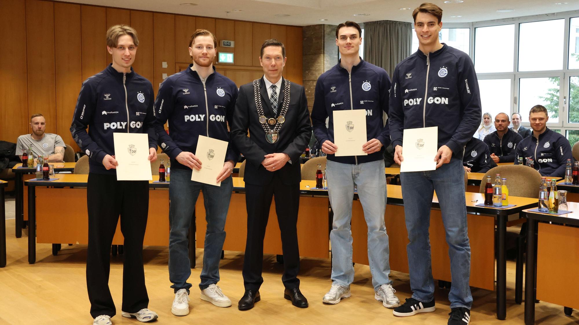 Bürgermeister Raoul Halding-Hoppenheit mit den Handballern Mathis Häseler, Tom Kiesler, Miro Schluroff und Julian Köster.