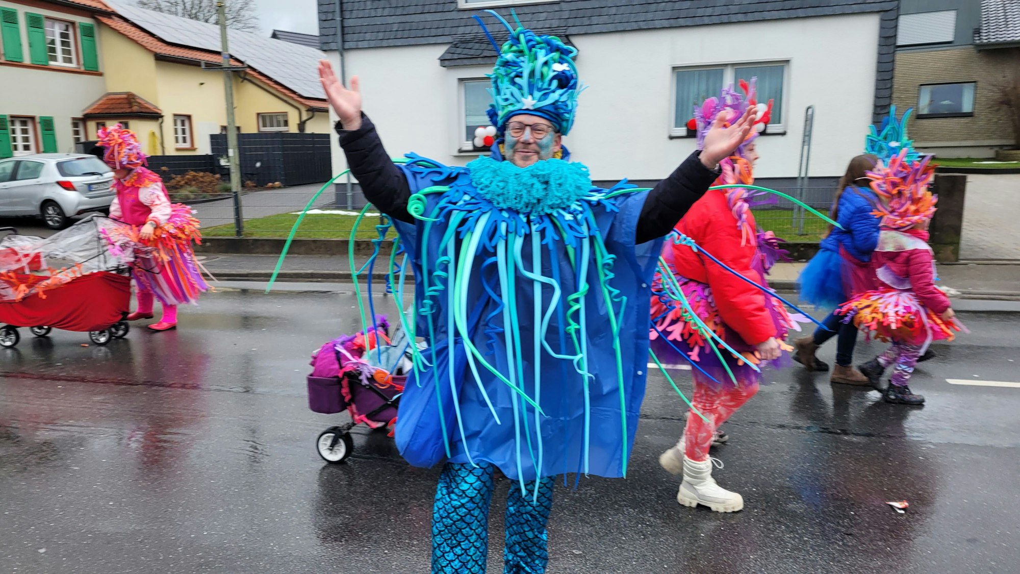 Das Foto zeigt einen Mann, der ein blaues Korallenkostüm trägt