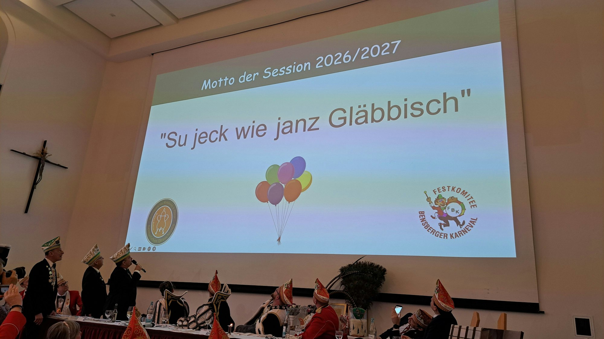 „Su jeck wie janz Gläbbisch“ steht auf einer Videoprojektion im Kardinal-Schulte-Haus beim traditionellen Prinzenessen am Veilchendienstag.