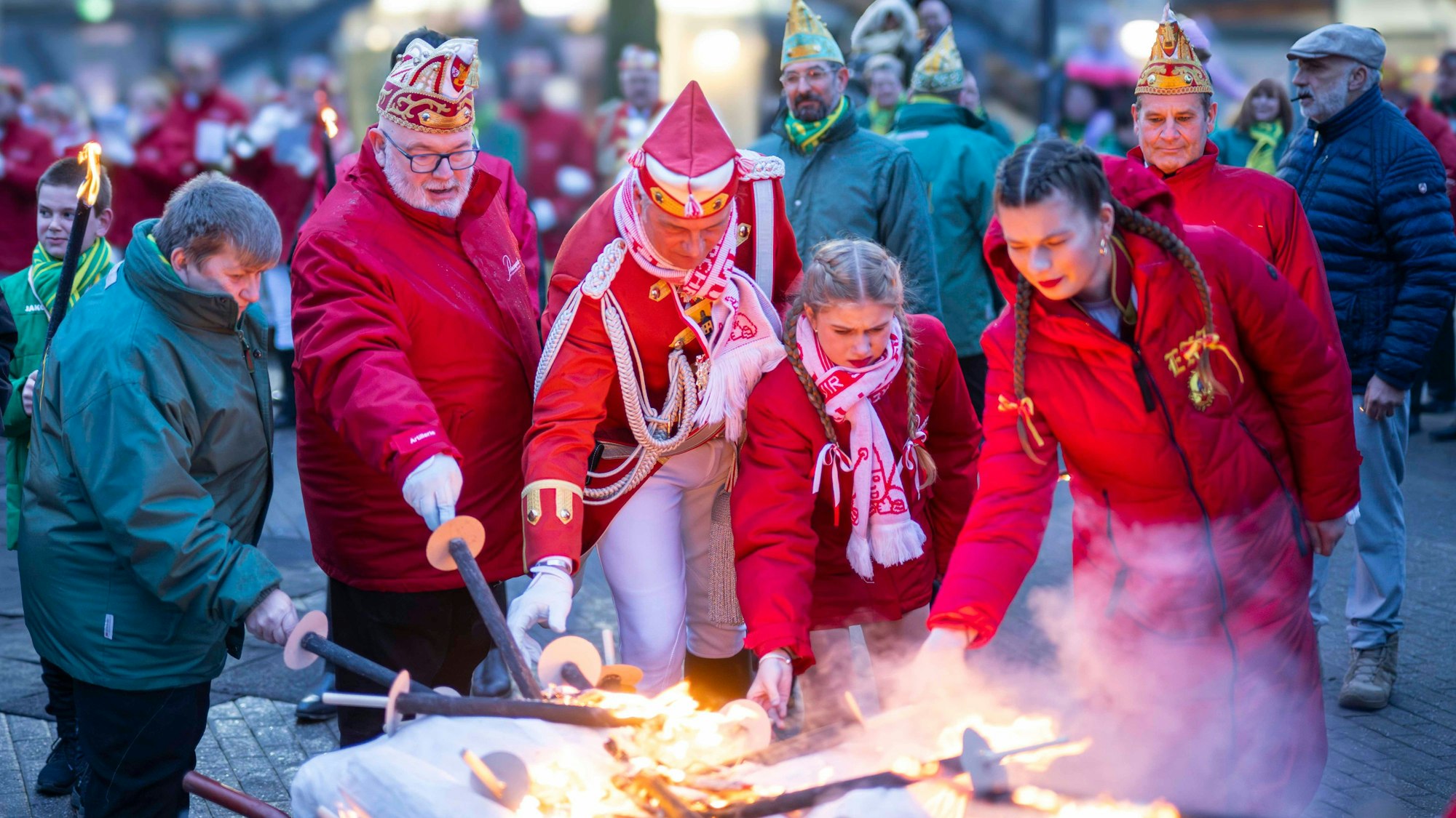 Das Bild zeigt einige Karnevalisten, die den Nubbel in Brand setzen.