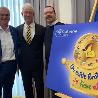 Zu sehen sind Dr. Marc Prokop, Georg Müller und Martin Lösch, sie stehen hinter einem Schild, das das Sessionsmotto zeigt.