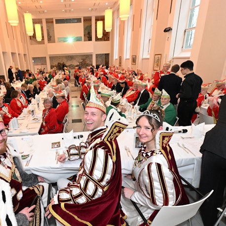 Prinz Thomas III. Bauer Maurice und Jungfrau Lea sitzen an einem Tisch beim Prinzenessen im Kardinal-Schulte-Haus.
