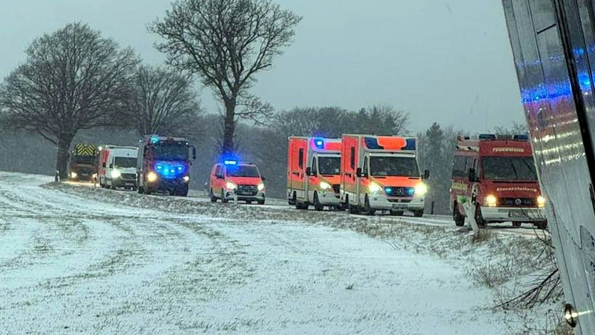 Feuerwehr- und Rettungsfahrzeuge stehen auf einer winterlichen Straße bei Wermelskirchen.
