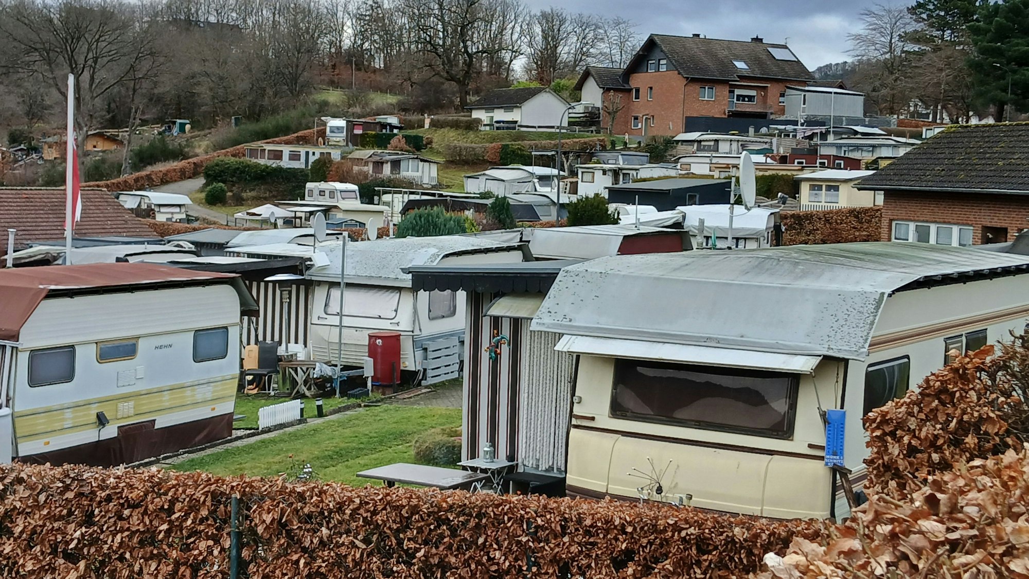 Wohnwagen auf dem Campingplatz am Ortsrand von Rurberg, zum Teil winterfest gemacht mit Planen.