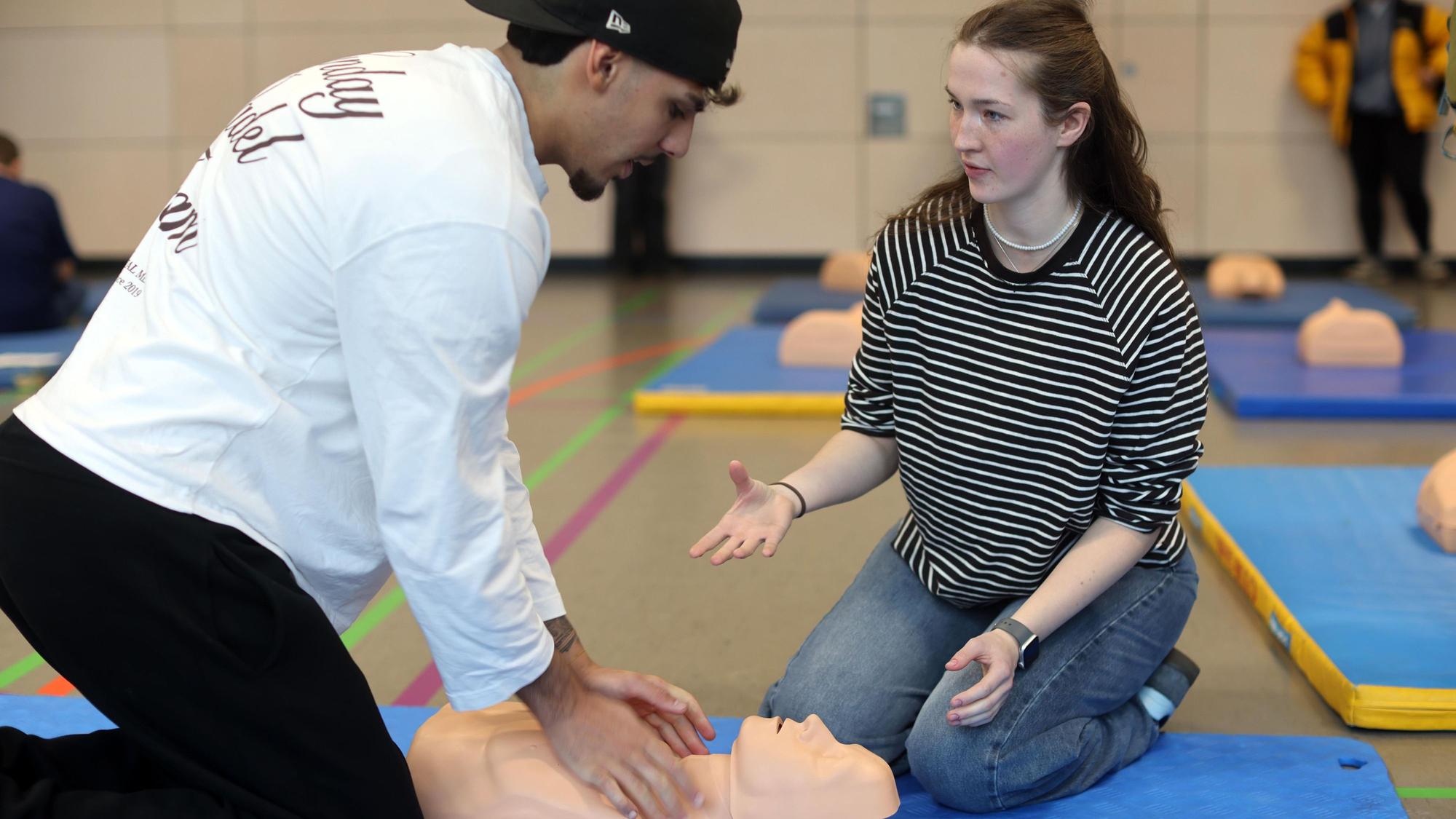 Die angehende Pflegefachfrau Franca Tuchscherer erklärt Schüler Nima Hückelheim im Rahmen eines Workshops, wie eine Reanimation funktioniert.