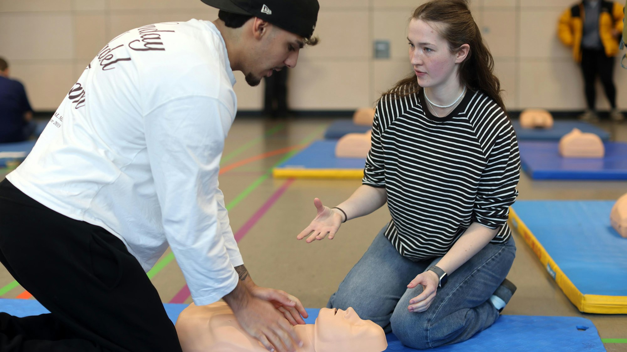 Die angehende Pflegefachfrau Franca Tuchscherer erklärt Schüler Nima Hückelheim im Rahmen eines Workshops, wie eine Reanimation funktioniert.