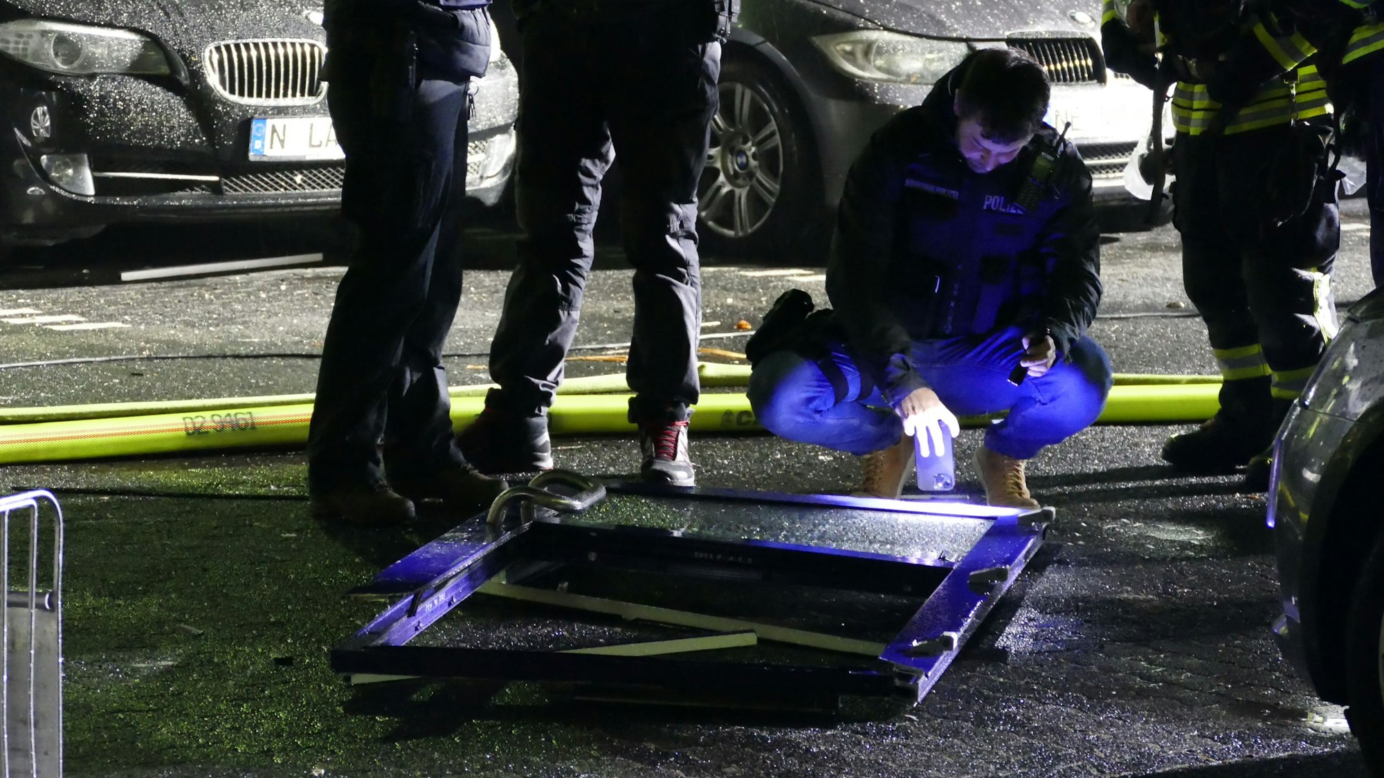 Ein Polizist untersucht die Eingangstür, die rund zehn Meter weit vor dem Gebäude lag.