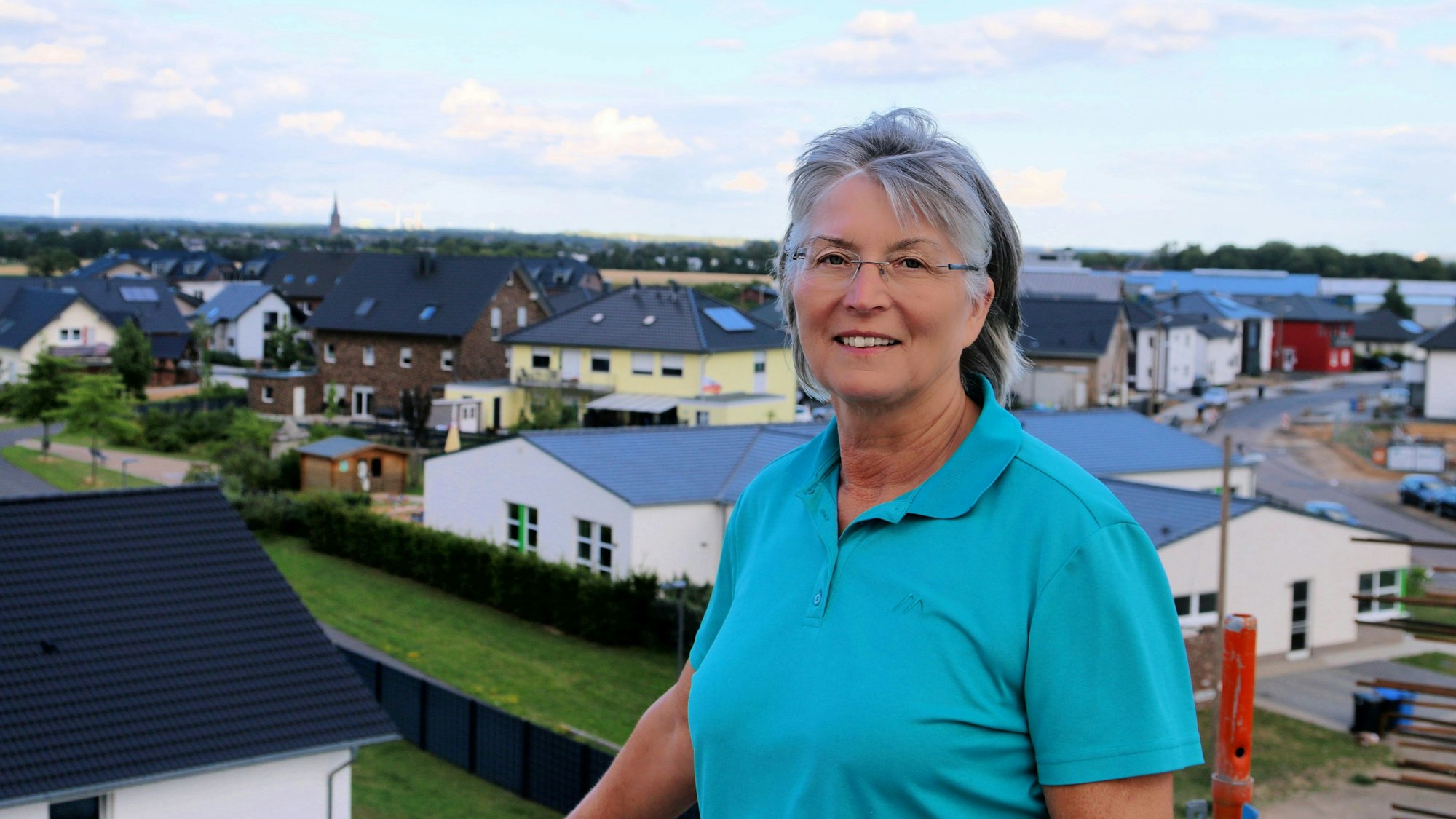 Das Foto zeigt eine Frau vor einer dörflichen Kulisse.