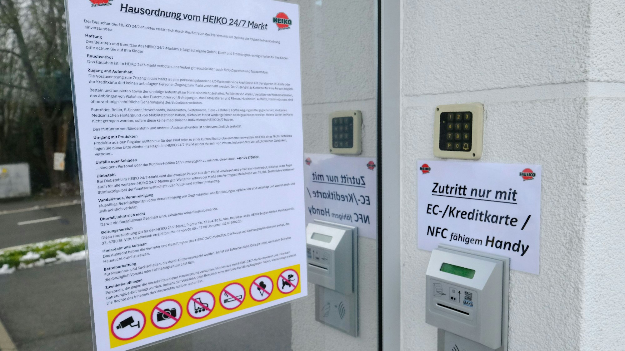 Aushang der Hausordnung und Einlass per EC-Karte am Eingang zum 24/7-Supermarkt.