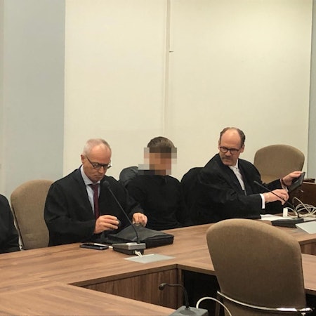 Das Foto zeigt zwei Anwälte mit ihren Anwälten, die unkenntlich gemacht wurden.