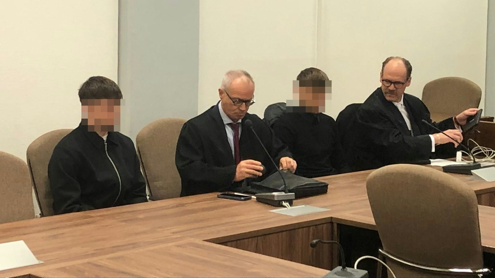 Das Bild zeigt die beiden Angeklagten mit ihren Anwälten.