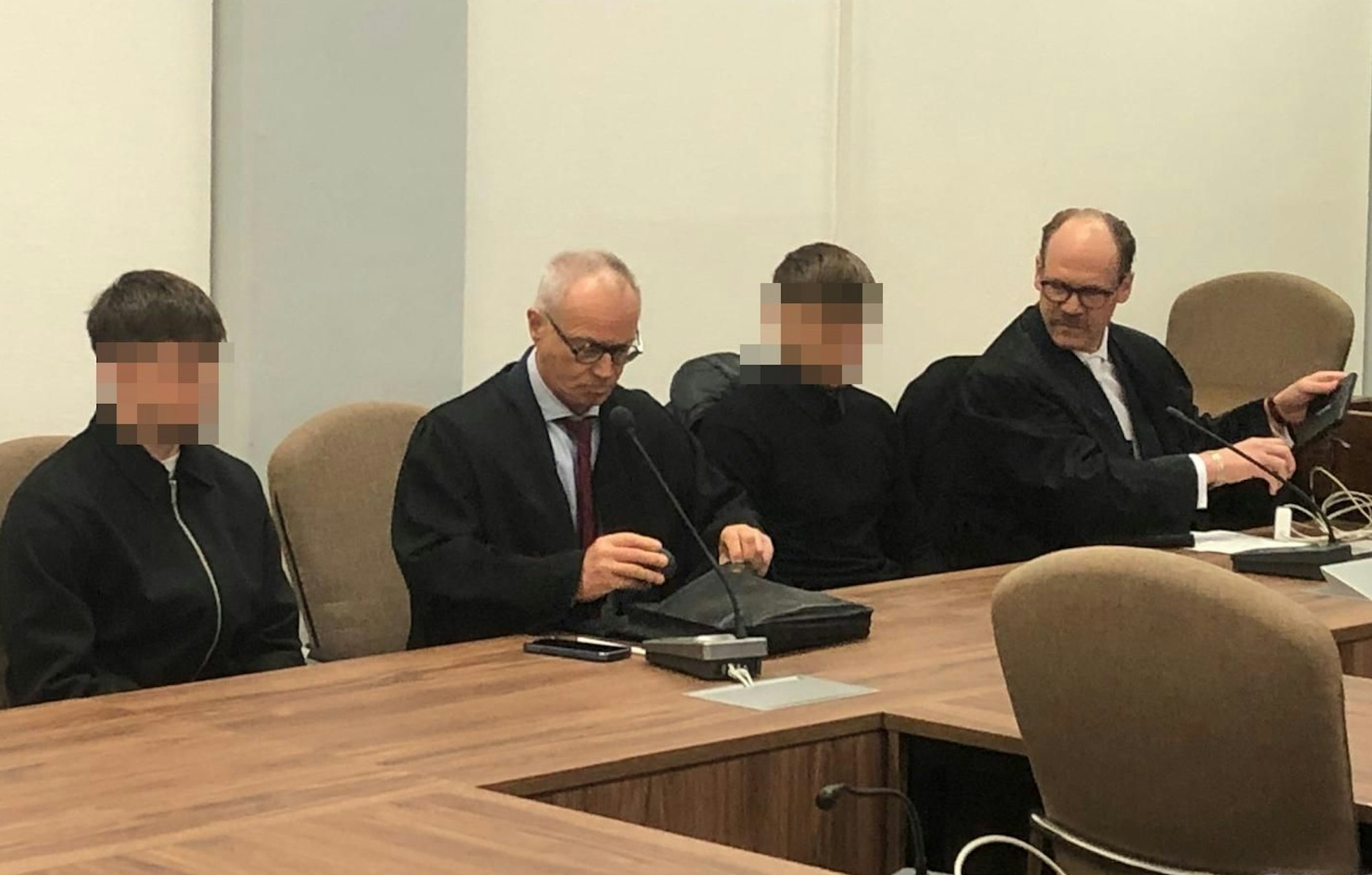 Die beiden Angeklagten sitzen im Landgericht neben ihren Anwälten. Die jungen Männer sollen sich Ende 2023 auf der A555 ein Rennen geliefert haben.