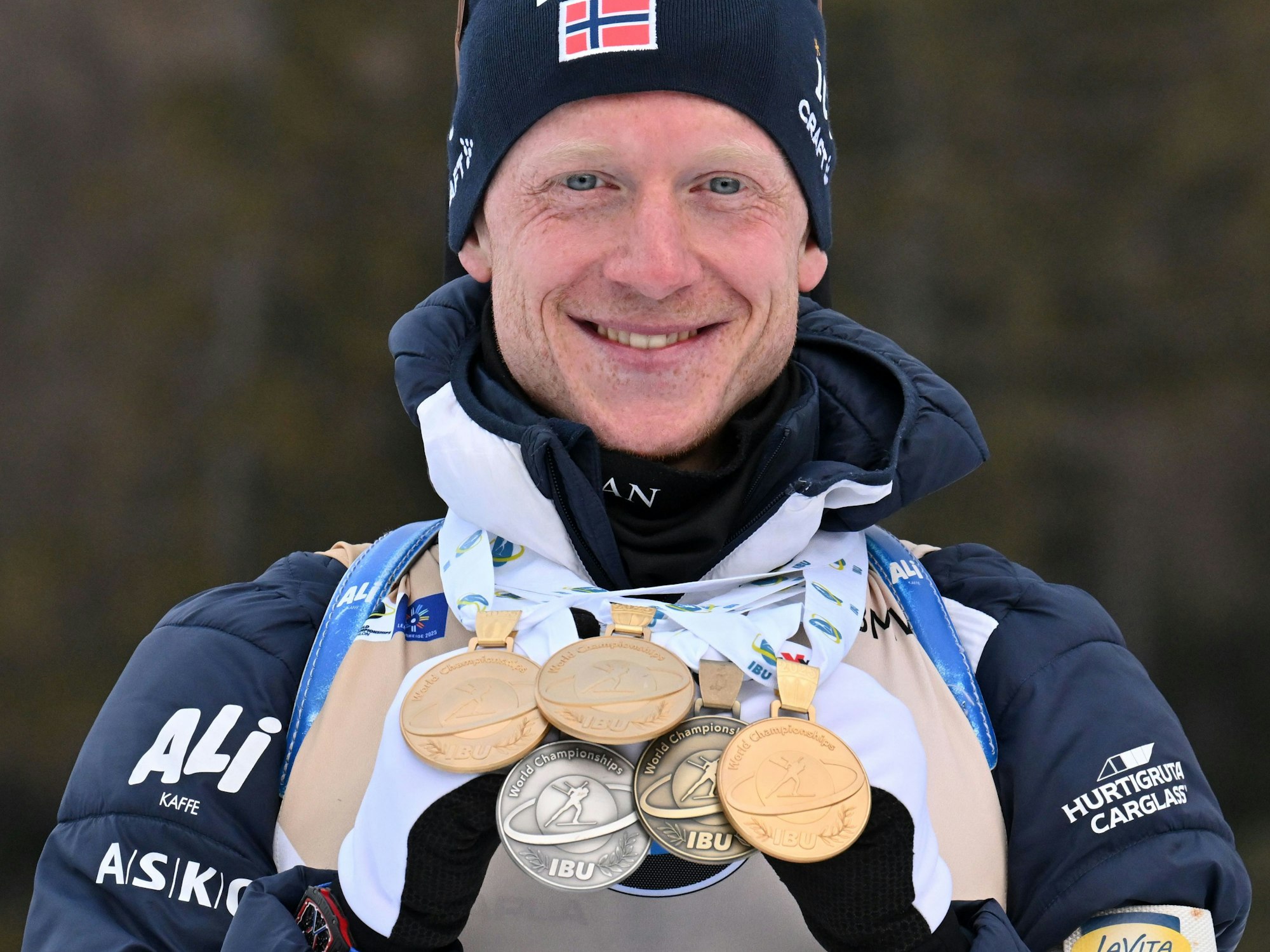 Johannes Thingnes Bö aus Norwegen präsentiert seine Medaillen.