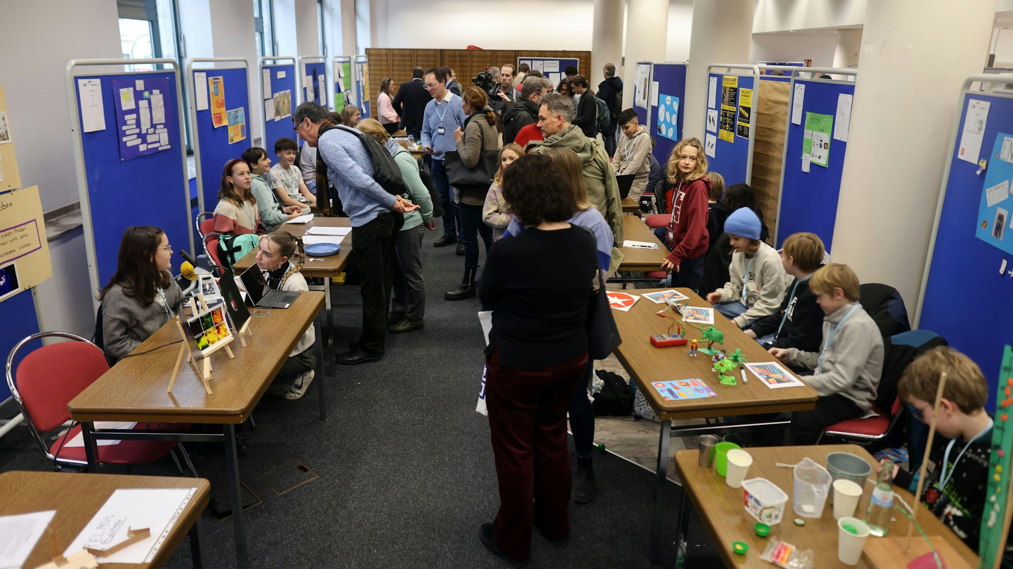 Kinder an Ständen hinter ihren Erfindungen