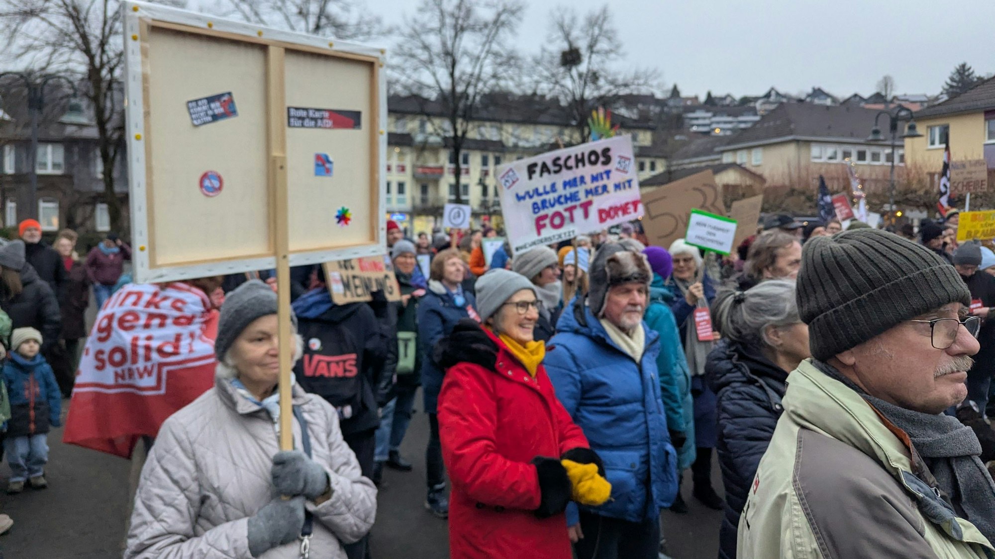 Menschen halten Protestplakate auf dem Overather Bahnhofplatz in die Höhe.